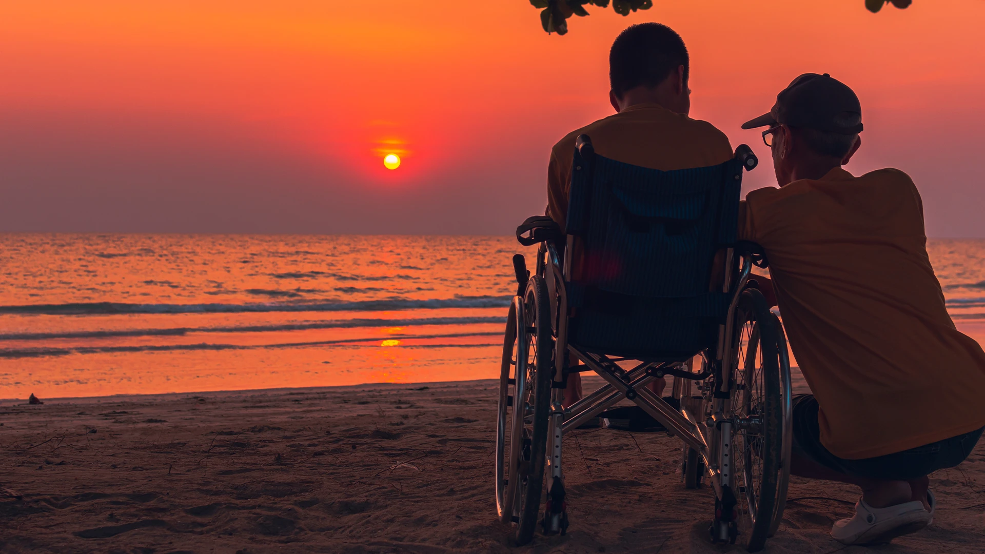 A wheelchair user looking out over the sea on the Greek coast at golden hour.